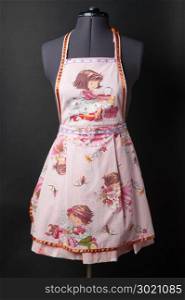 Female kitchen apron on a mannequin on a black background