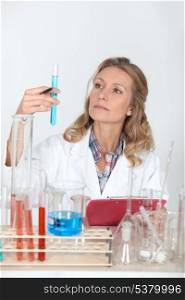 Female lab technician looking at test tubes