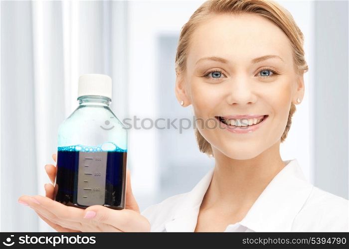 female lab worker holding up bottle with blue liquid