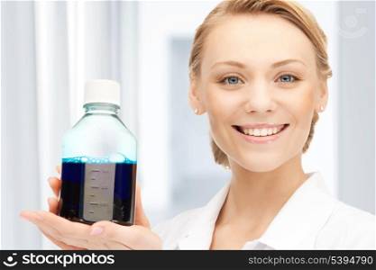 female lab worker holding up bottle with blue liquid