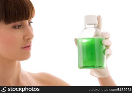 female lab worker holding up bottle with green liquid