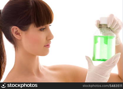 female lab worker holding up bottle with green liquid