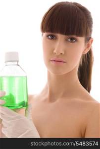 female lab worker holding up bottle with green liquid