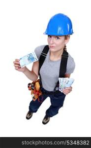 Female laborer holding wad of bills