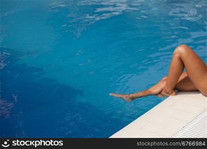 Female legs in the swimming pool