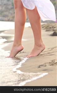 female legs on sunrise beach