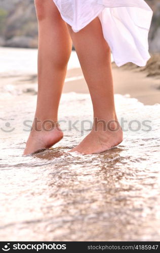 female legs on sunrise beach