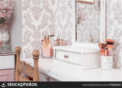 female makeup table with makeup including brushes and mirror. pink colors, girl design beauty and fashion. female makeup table with makeup including brushes and mirror. pink colors, girl design