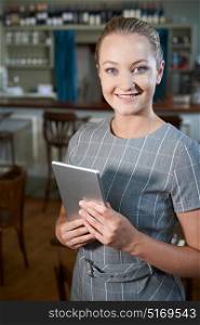 Female Manager In Restaurant With Digital Tablet