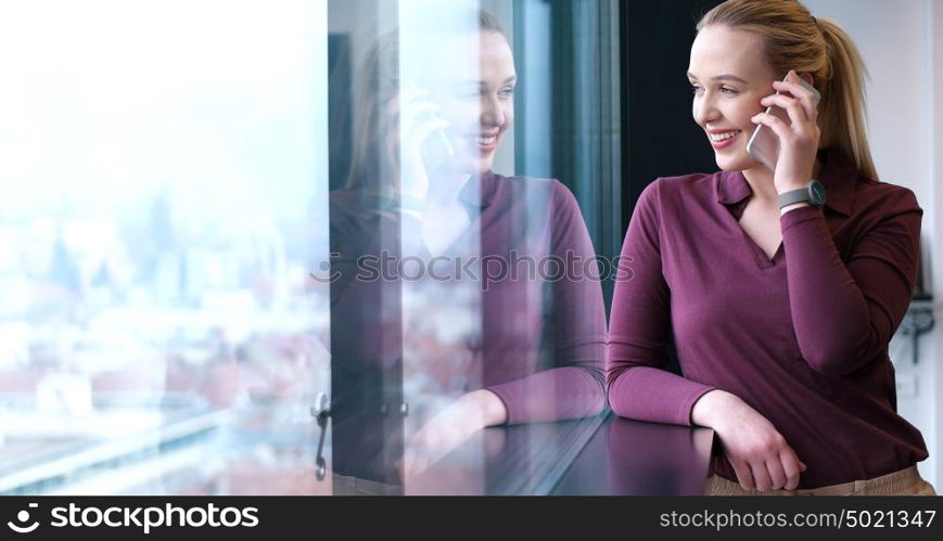 female manager using cell telephone in office interior