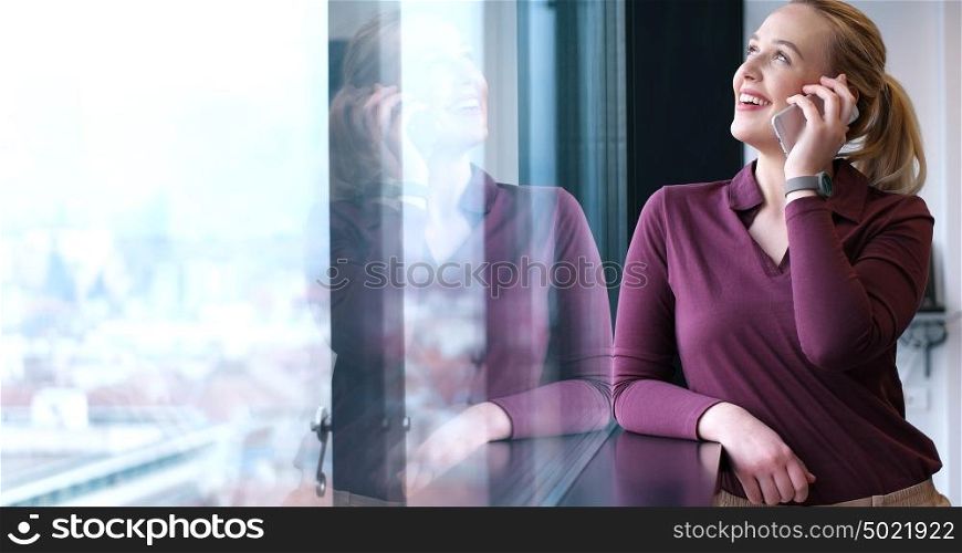 female manager using cell telephone in office interior