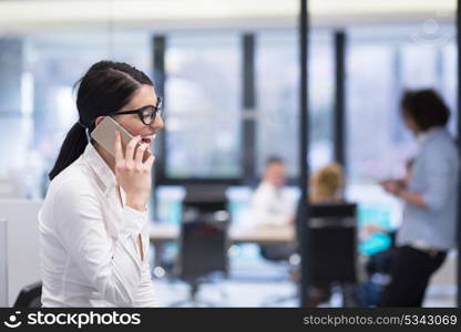 female manager using cell telephone in startup office interior