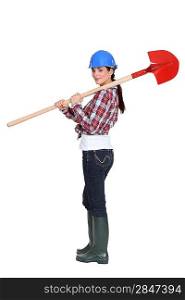 Female manual worker carrying shovel