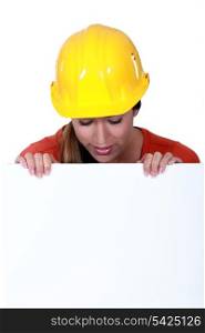 Female manual worker staring at blank poster