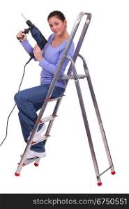 Female manual worker with drill and ladder