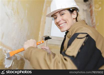 female mason demolishing the wall