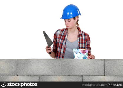 Female mason stood with trowel