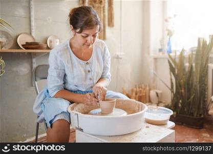 Female master making a pot on pottery wheel. Woman molding a bowl. Handmade ceramic art, tableware from clay. Female master making a pot on pottery wheel
