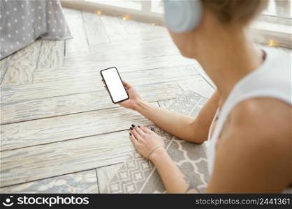 female mat with headphones using phone