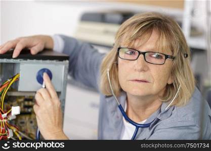 female mature technician checking a pc