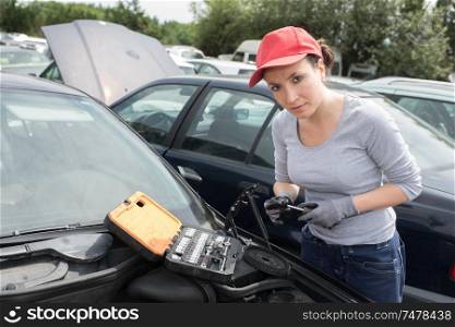 female mechanic changing tire with wheel wrench