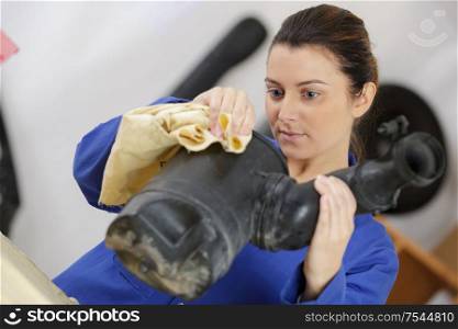 female mechanic cleaning automotive air filter