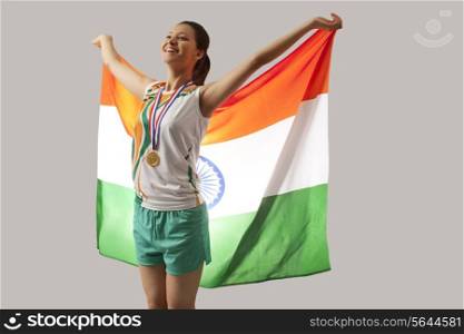 Female medalist celebrating victory with Indian flag isolated over gray background