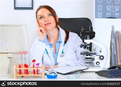 Female medical doctor sitting in cabinet and dreaming&#xA;