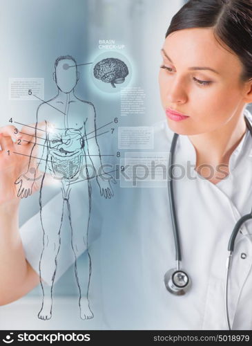 Female medical doctor working with virtual interface examining human male body