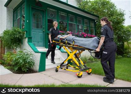 Female medical team taking elderly woman to hospital