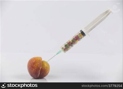 Female menopause and sexual disease metaphor: peach and syringe with meaning cosmetic and health treatment for female ageing