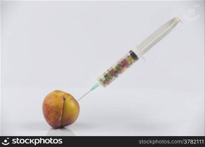 Female menopause and sexual disease metaphor: peach and syringe with meaning cosmetic and health treatment for female ageing