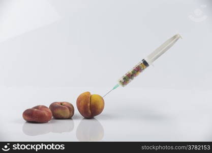 Female menopause and sexual disease metaphor: peaches and syringe with pills meaning cosmetic and health treatment for female ageing