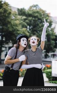 female mime pointing upwards showing something male mime
