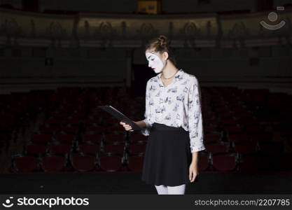 female mime reading manuscript stage