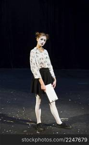 female mime with manuscript standing stage
