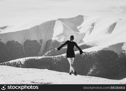 Female model in dress on mountain monochrome scenic photography. Picture of person with snow capped peaks on background. High quality wallpaper. Photo concept for ads, travel blog, magazine, article. Female model in dress on mountain monochrome scenic photography