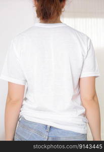 Female model wearing a white t-shirt, back view. T-shirt mockup, template for picture, text or logo. Free space, copy space. Female model wearing a white t-shirt, back view. T-shirt mockup, template for picture, text or logo. Free space, copy space.