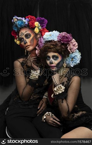Female models with a sugar skull makeup dressed with flower crown. Halloween concept