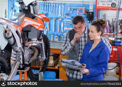female motorbike mechanic inspecting the bike