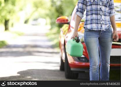 Female Motorist Carrying Fuel Can Next To Broken Down Car