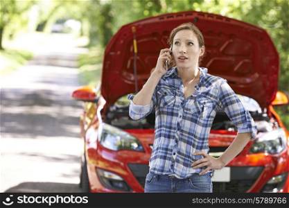 Female Motorist Phoning For Help After Breakdown