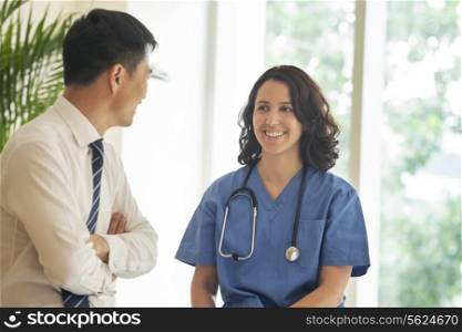 Female nurse and patient talking and smiling in the hospital