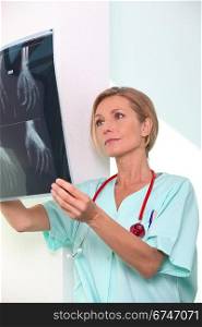 Female nurse examining x-ray print