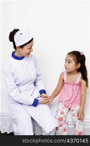 Female nurse holding a girl&acute;s hand