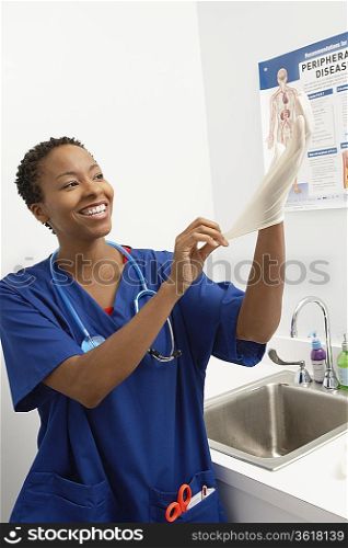 Female nurse putting on gloves in hospital
