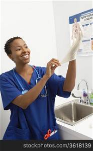 Female nurse putting on gloves in hospital