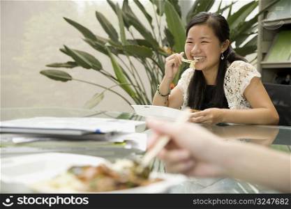Female office worker having lunch and smiling