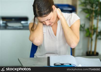 female office worker massaging aching neck