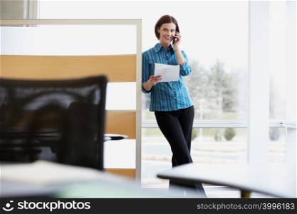 Female office worker using a cellular telephone